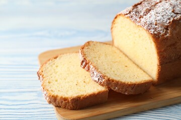 Freshly baked sponge cake on light blue wooden table, closeup