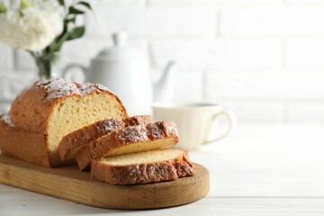 Freshly baked sponge cake on white wooden table, closeup. Space for text