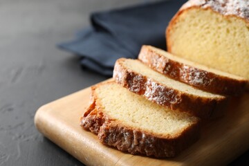Freshly baked sponge cake on black table, closeup