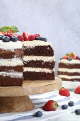 Delicious chocolate sponge cake with berries served on white table
