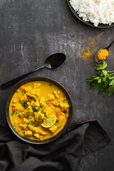 Bowl with chicken curry with vegetables on dark background. Indian cuisine. Thai Chicken Curry With Coconut Milk. Coconut. Thai Panang Curry. Top view, space for text. Food photography for restaurant