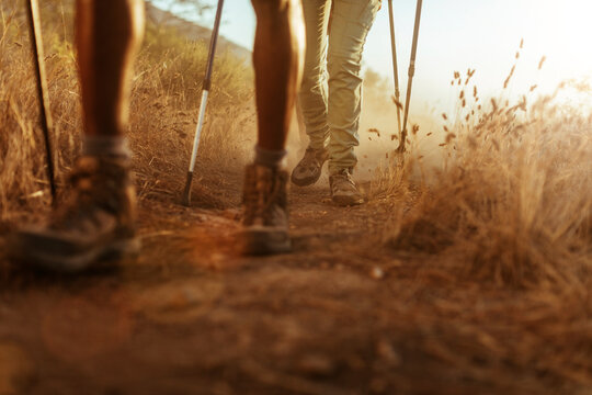 Close-up of hikers' boots on a dusty trail