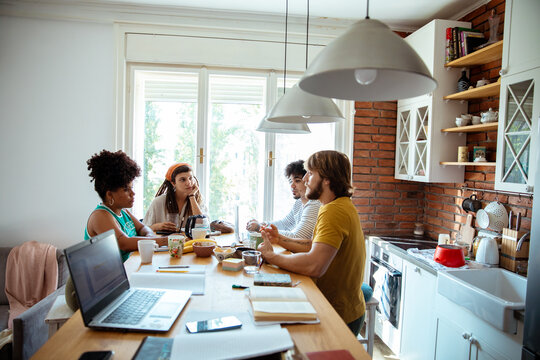 Group of friends studying together at the kitchen table