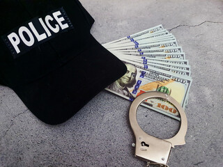 Police cap with handcuffs and US dollar bills.