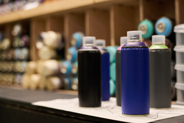 Unopened navy blue can with graffiti paint standing on display in front of other dispensers in...