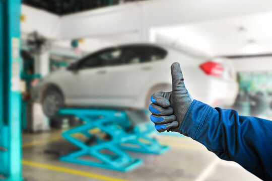 Thumb up for car repair work , The auto mechanic gives a thumb up to show confidence in a good job , Car maintenance service concept