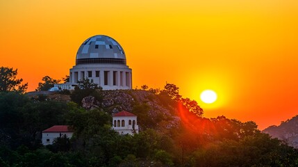 Obraz premium Radar Dome at Sunset: Silhouetted against a vibrant orange sky, a radar dome sits atop a hill. The geometric structure contrasts with the natural landscape, symbolizing our ability to monitor 