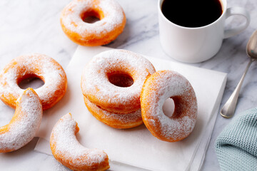 Coffee with classic donut on white marble table background. Top view. Close up.