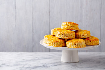 Scones, traditional British bakery on cake stand. Grey background. Copy space.