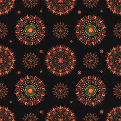 Seamless kwanzaa pattern with circular and star shapes forming a mandala, in green, red, orange and yellow on black background