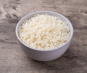 Cooked white rice in a bowl over wooden table