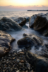 red sunset in the surf on the rocks and splashes