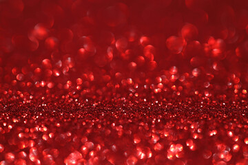 Red glitter bokeh background with sparkling light, abstract defocused texture. Holiday lights.