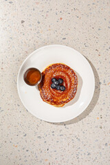 Portion of appetizing sweet pancakes with blueberries and sauce