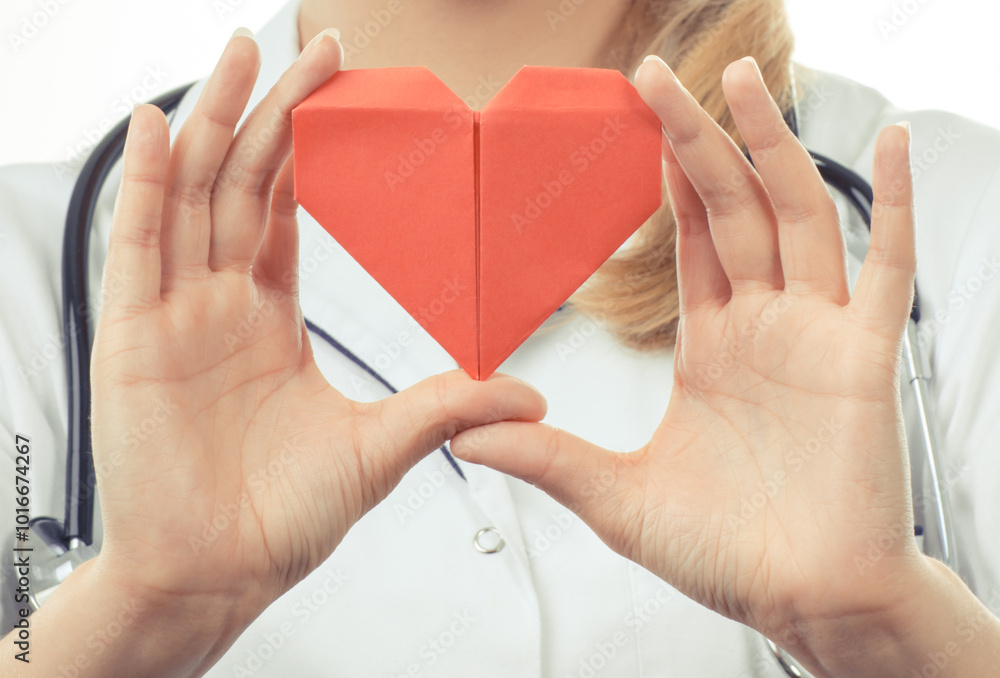 Wall mural hand of doctor holding red heart made of paper. health care and treatment