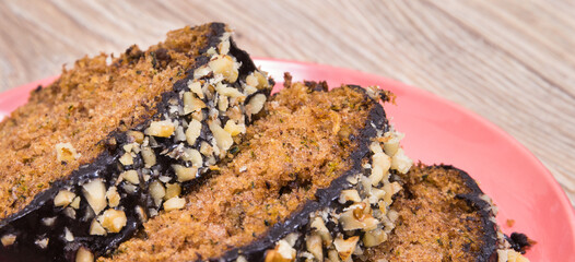 Pastry made of zucchini with nuts and raisin on wooden board. Delicious dessert