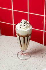 Glass of appetizing sweet milkshake cocktail with syrup