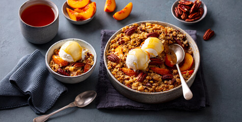 Crumble with ice cream in bowl. Grey background. Close up.