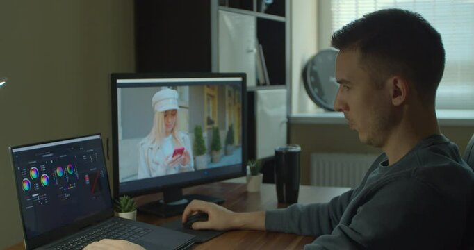 Man working on computer with Two Monitors Color Correction Post Production video or photo in Progress Closeup.