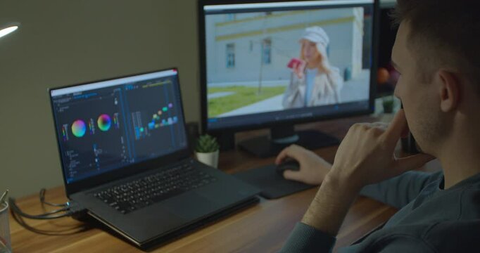 Man working on computer with Two Monitors Color Correction Post Production video or photo in Progress Closeup.