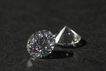 Two beautiful shiny diamond on black table, closeup
