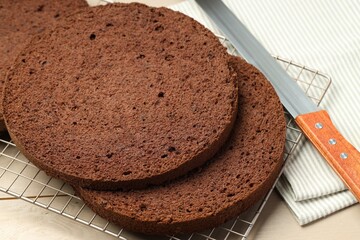 Cut tasty chocolate sponge cake and knife on wooden table, closeup