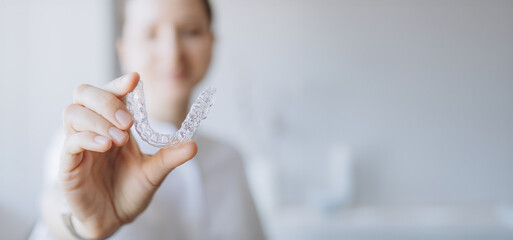 Doctor Showing A Transparent Aligner Tray, Holding Invisalign-Like For Orthodontic Treatment. New Technology For Teeth Straightening. Dental Health Medical Care Concept.