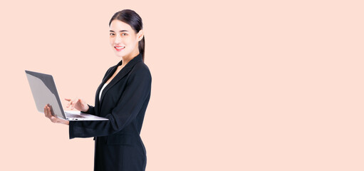 Professional young business woman in a black suit confidently holding and working on a laptop, symbolizing modern business, technology, and corporate professionalism.