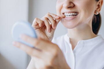 Woman Putting On Invisible Removable Braces Aligner, Orthodontic Treatment To Align Teeth