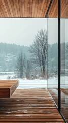 Modern wooden deck overlooks a serene winter landscape with snow and bare trees, showcasing a tranquil interior design.