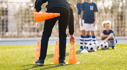 Young man coaching children in physical education class. Soccer practice for children. Coach...