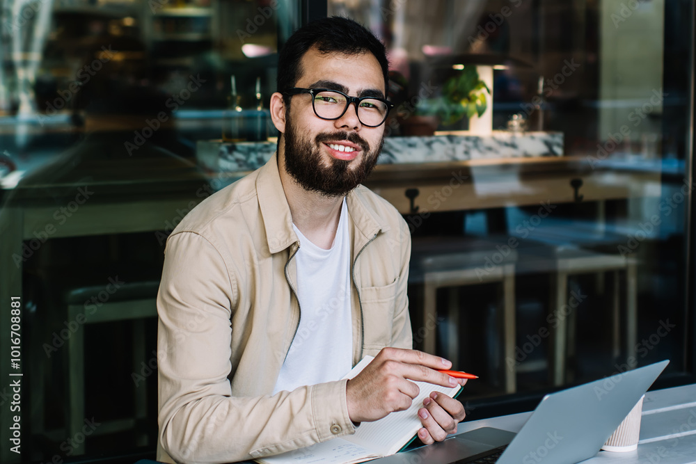 Poster portrait of happy asian male student in optical spectacles for vision correction smiling at camera w