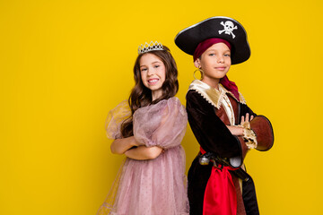 Portrait of two small kids halloween pirate princess costume crossed arms empty space isolated on yellow color background © deagreez