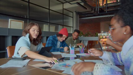 Team of workers engages in workflow at table in office
