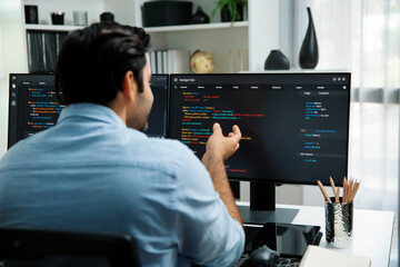 Concentrating in smart IT developer working software development coding on two pc screen, creating...