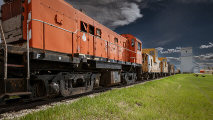 Derelict Canadian Pacific Railways locomotive and cabooses on abandoned siding near grain elevators at Mossleigh, Vulcan County, Alberta, Canada.