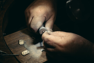 Master polishing jeweller ornament. Picture of hands and product close up.