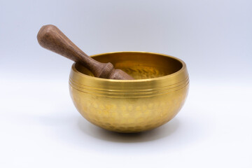 An image of a single meditation singing bowl with mallet on a white background.