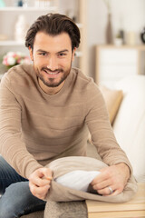 young attractive smiling guy at home on sofa