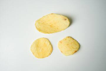 Crispy Yellow Wavy Snack on White Background – Minimalist Food Photography