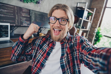 Selfie of funny blond hair bearded server administrator wear casual plaid shirt photographing himself indoors office coworking