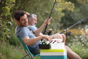 two male friends fishing together on the lake