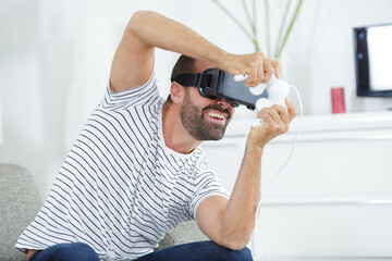 young man in vr mask sit on the sofa