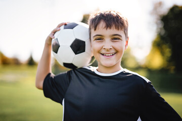 Sport, boy and football on field, trick practice and exercise for competition match. Soccer player,...