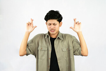 Worried Looking Young Handsome Male Boy with fingers crossed thinking and sad expressions lookg time