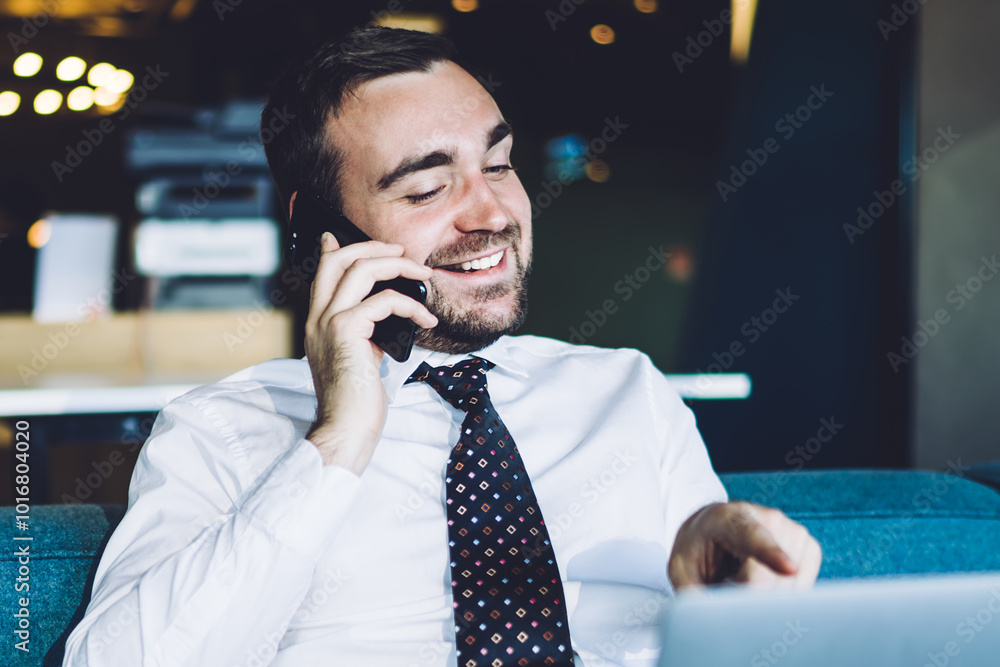 Poster successful male entrepreneur in formal wear reading funny email via laptop device and making smartph