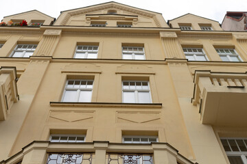 Gazing upwards at a towering structure with numerous large windows that create a unique facade and...