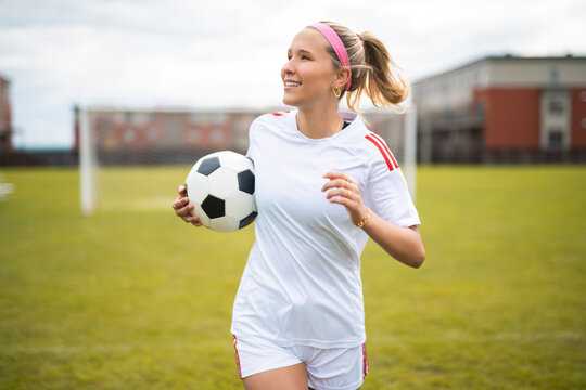 motivation soccer player with a football in a sport uniform wearing in white - Powered by Adobe