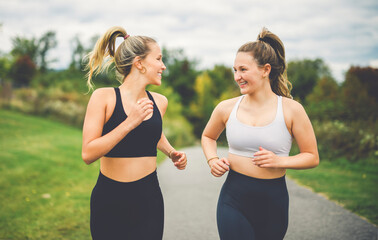 Healthy two sporty young girls jogging and running outdoors