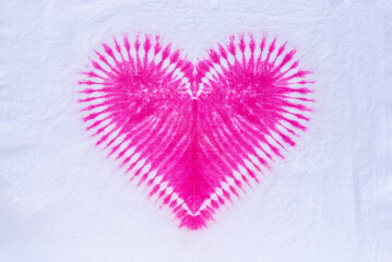 pink heart tie dye pattern hand dyed on cotton fabric background.